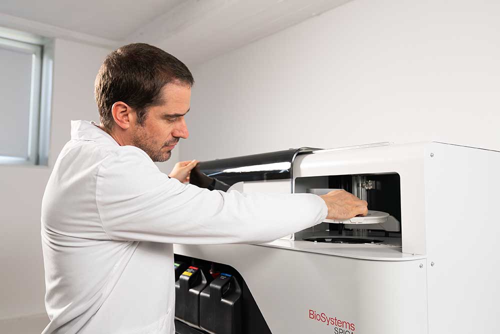 Winery laboratory technician reviewing results on an automated wine analyzer.