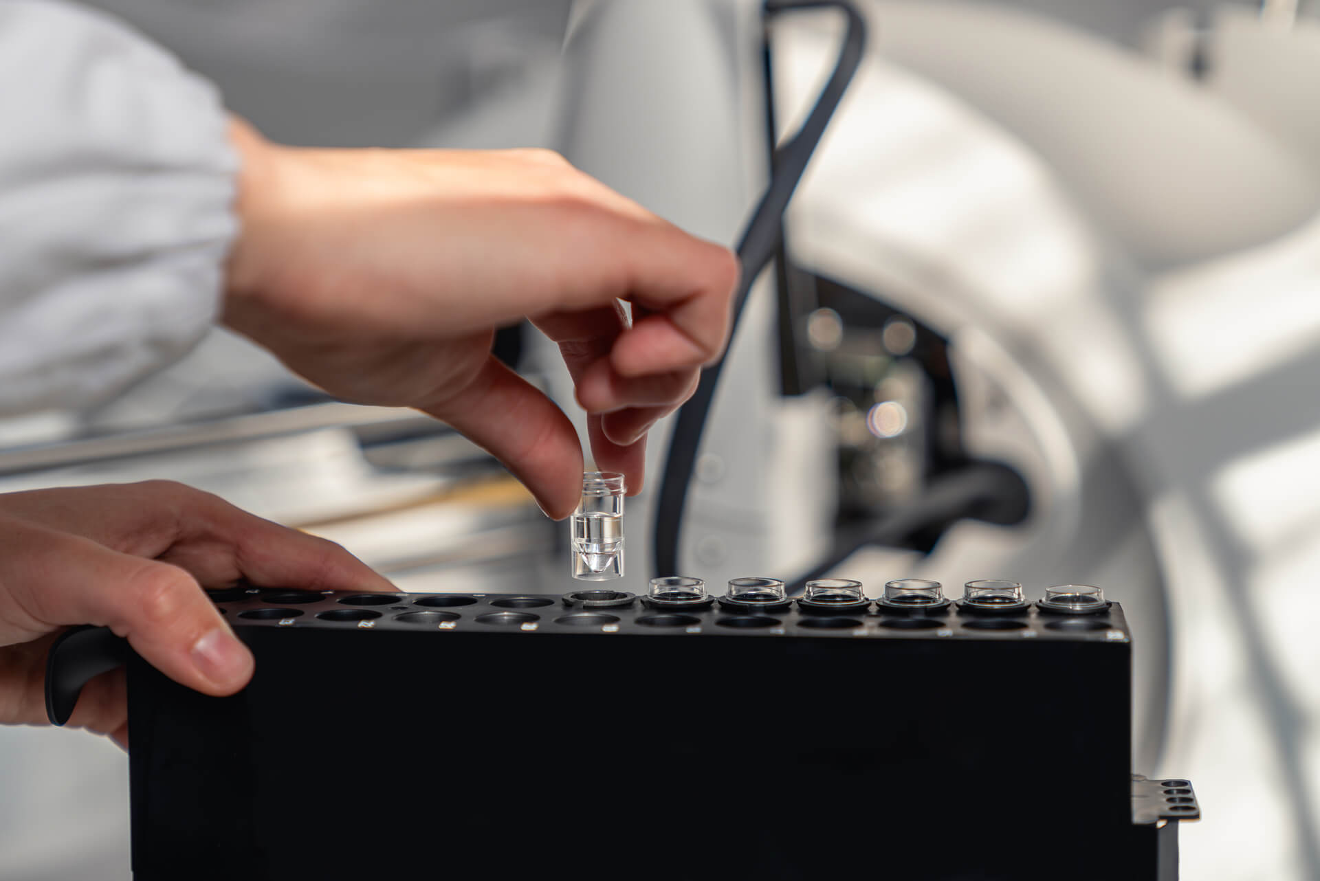 Person assembling a black electronic device with small components.