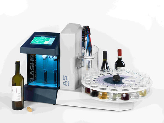 An automatic titrator machine, primarily white and blue in color, with bottles of varying colors placed around it, indicating a laboratory setting.