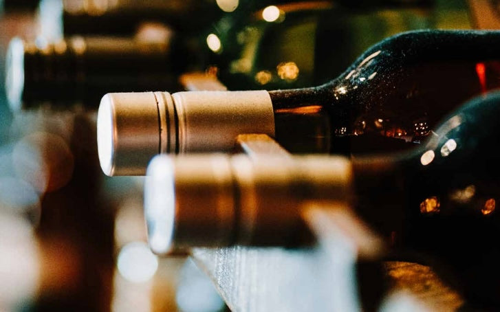 Close-up of wine bottles with corks on a wooden surface